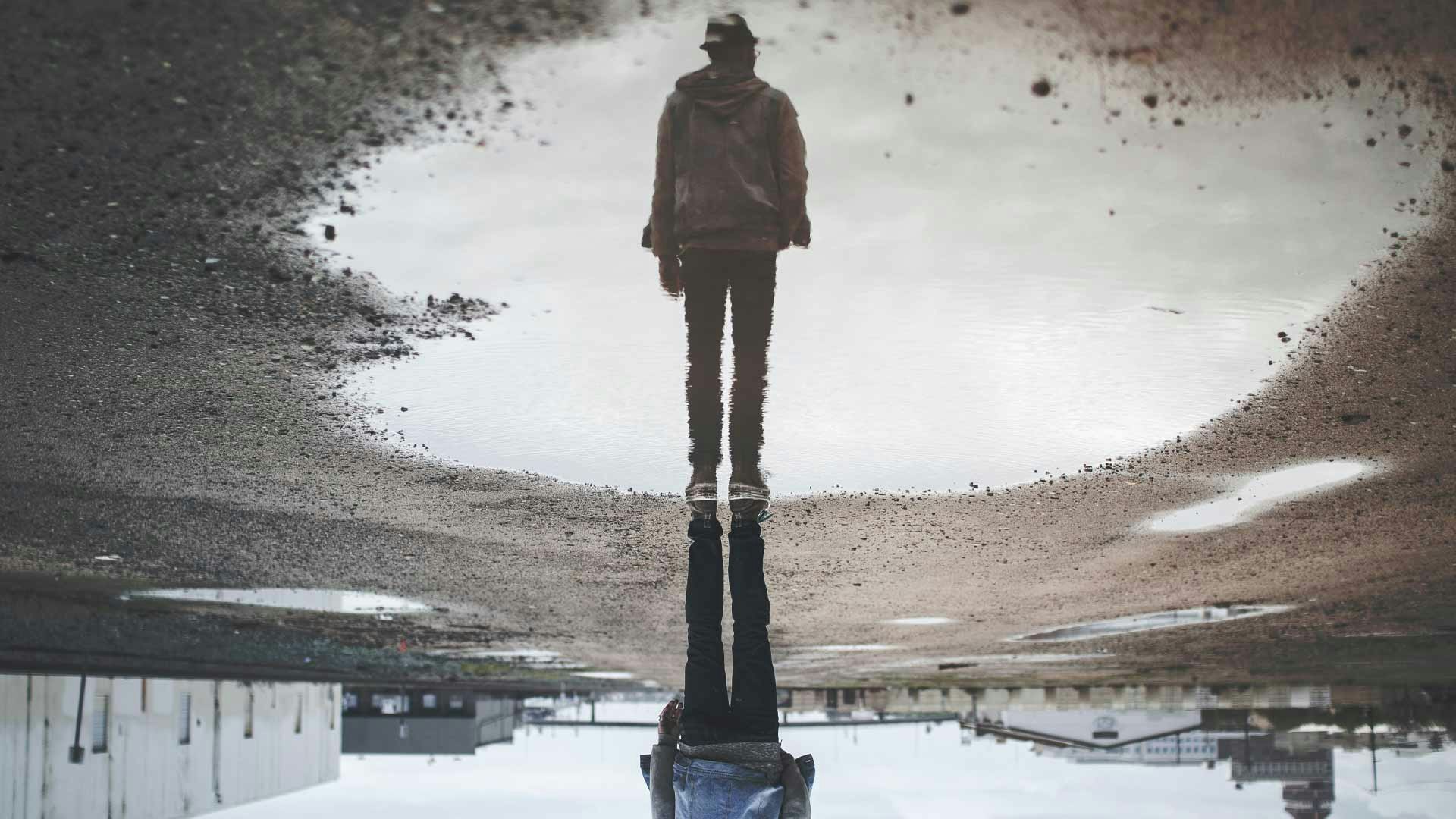 guy reflected in puddle